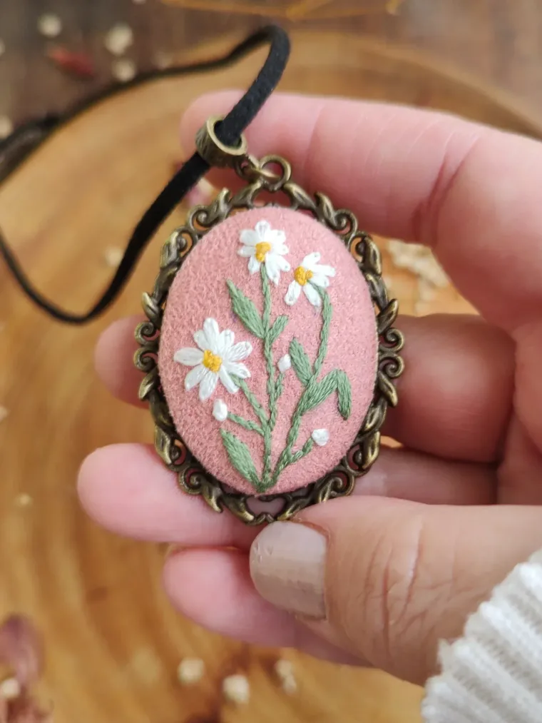 Colar oval rosê com margaridas bordadas